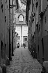 Naklejka premium narrow street n couple walking bw