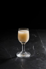 eggnog in liqueur glasses on a dark background 