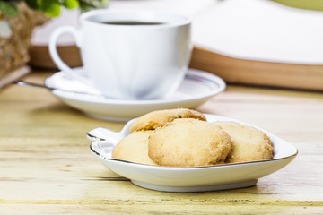 image cookies and  a cup of coffee with opened bible and flower on wooden table