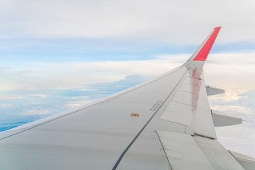 Wing of an airplane flying above the clouds .