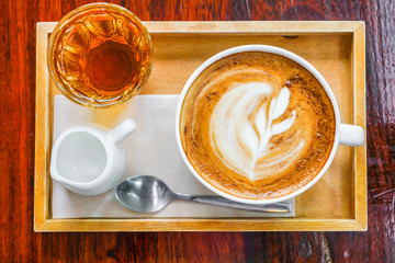 Latte Coffee art on the wooden table .
