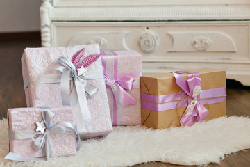 Holiday gift boxes decorated with ribbon. Beautiful purple shiny package for Christmas and New Year. Sebebryannaya tape