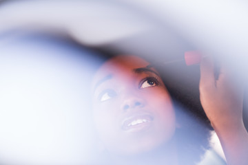 a young African-American woman makeup in the car