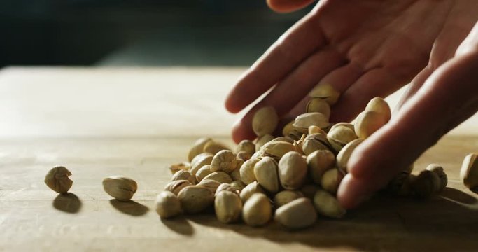 hands of a young chef cook who let go of some of the tasty pistachios Bronte in extreme slowmotion 