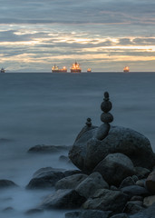 beach rocks with sunset ocean clouds background