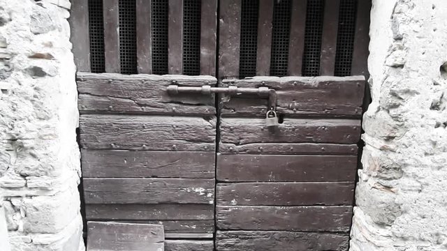 Old wooden door in medieval building, Bracciano, Lazio, Italy.