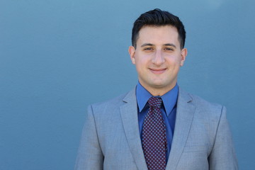 Smiling relaxed businessman poses for a half length portrait, isolated on blue