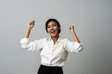 Successful business woman with arms up celebrating