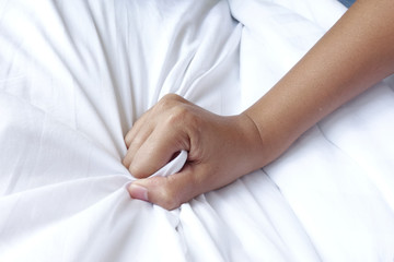 hand of women pulling white sheets in ecstasy, orgasm.