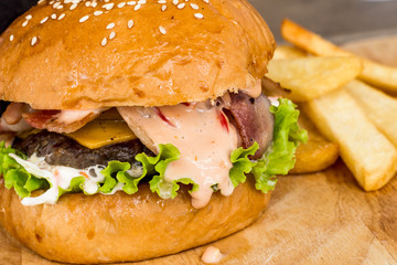 Hamburgers and French fries on the wood.