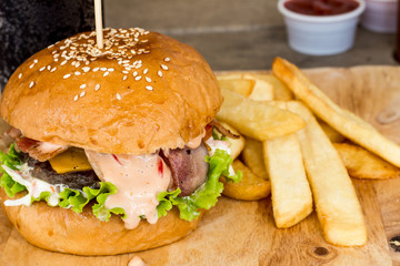Hamburgers and French fries on the wood.