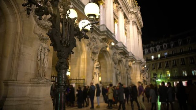 View on antique streetlight and people entering Opera house in Paris, France