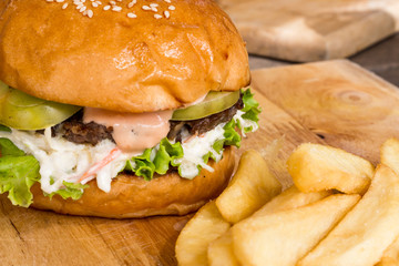 Hamburgers and French fries on the wood.