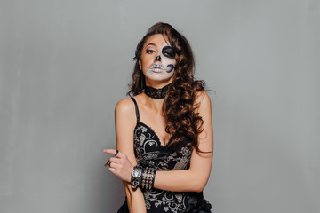 Portrait of young woman with skull make-up.