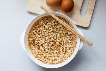 boil instant noddles with eggs on the white table