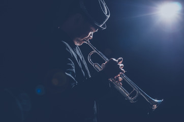 Musician playing the Trumpet with spot light and len flare on th