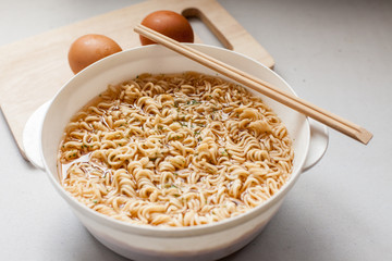boil instant noddles with eggs on the white table