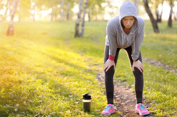 Woman having a rest after hard workout on a sports field.
