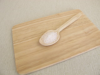 Fototapeta na wymiar Sechs Gramm Salz pro Tag auf einem Holzlöffel