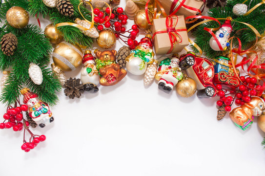 Christmas or New Year background: fur-tree, branches, gifts, colored glass balls and toy, decoration and cones on a white background