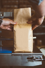 Person holding weighing coffee in bag