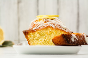 Lemon loaf with white glaze on wooden background