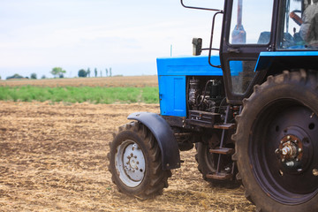 Naklejka premium Old blue tractor in a field