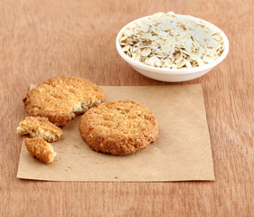 Homemade, healthy food oatmeal cookie and in the background oats in a bowl.