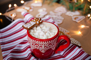 Red mugs with hot chocolate and marshmallows and gingerbread cookies. Christmas holiday concept