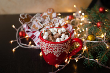 Red mugs with hot chocolate and marshmallows and gingerbread cookies. Christmas holiday concept