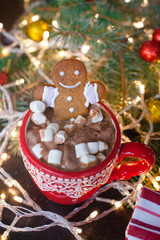 Red mugs with hot chocolate and marshmallows and gingerbread cookies. Christmas holiday concept