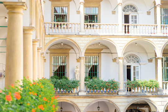 Architecture. Facade of beautiful building with colomn and balconies, and flowers on it.