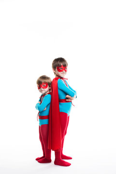 Two boy superhero with a mask and cloak full length look at camera.
