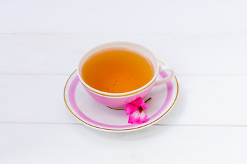 Pink cup with tea and saucer