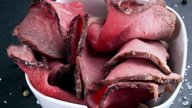 Roastbeef (not loopable; 4K) on a slate slab (close-up shot)