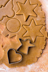 Cookies forms and gingerbread dough on wooden pastry board