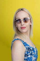 caucasian woman wearing sunglasses over yellow background