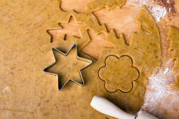 Cookies forms and gingerbread dough on wooden pastry board