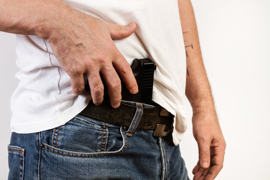 Hombre con pistola en la cintura. Concepto delincuencia. Vista de perfil y de cerca