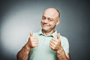 middle-aged man of average shows a sign ok hands.