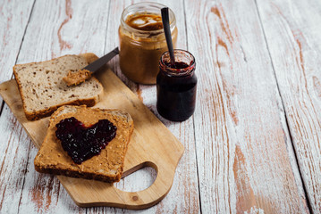 Homemade peanut butter and jelly sandwich on wooden background