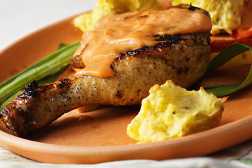 Chicken leg with potatoes closeup