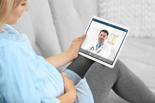 Pregnant Woman Video Chatting With Doctor On Tablet. Professional Medical Online Consultation Concept.