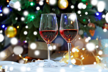 Glasses of red wine on blurred Christmas interior background. Christmas celebration concept.