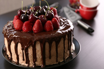 Delicious cake with cherry and strawberry on table