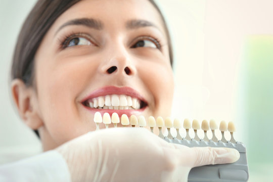 Dentist matching teeth colour in office