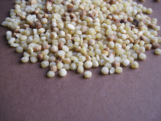Fregola pasta on brown background