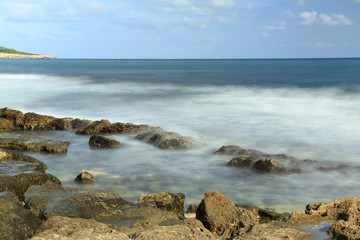 Fototapeta na wymiar waves crashing on stones, long exposure