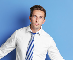 Young happy businessman on blue background