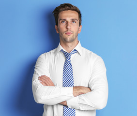 Young happy businessman on blue background